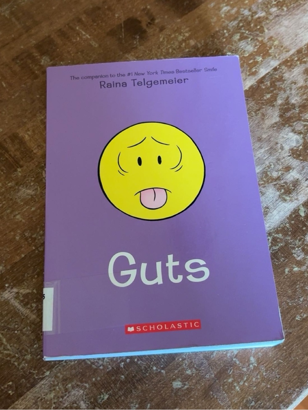 Scholastic Guts Graphic Novel — Purple Cover with Yellow Emoticon